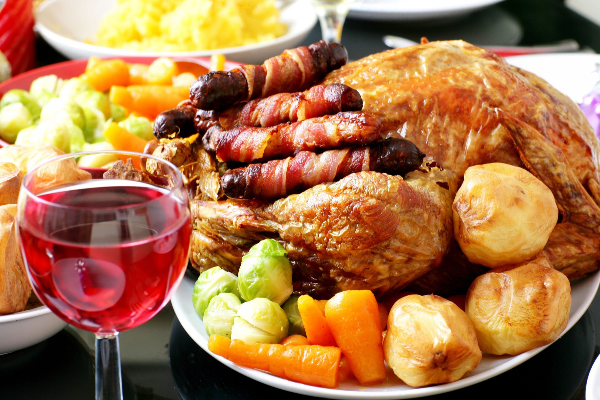 pollo frito patatas zanahorias guarnición copa de vino salchichas verduras mesa festiva