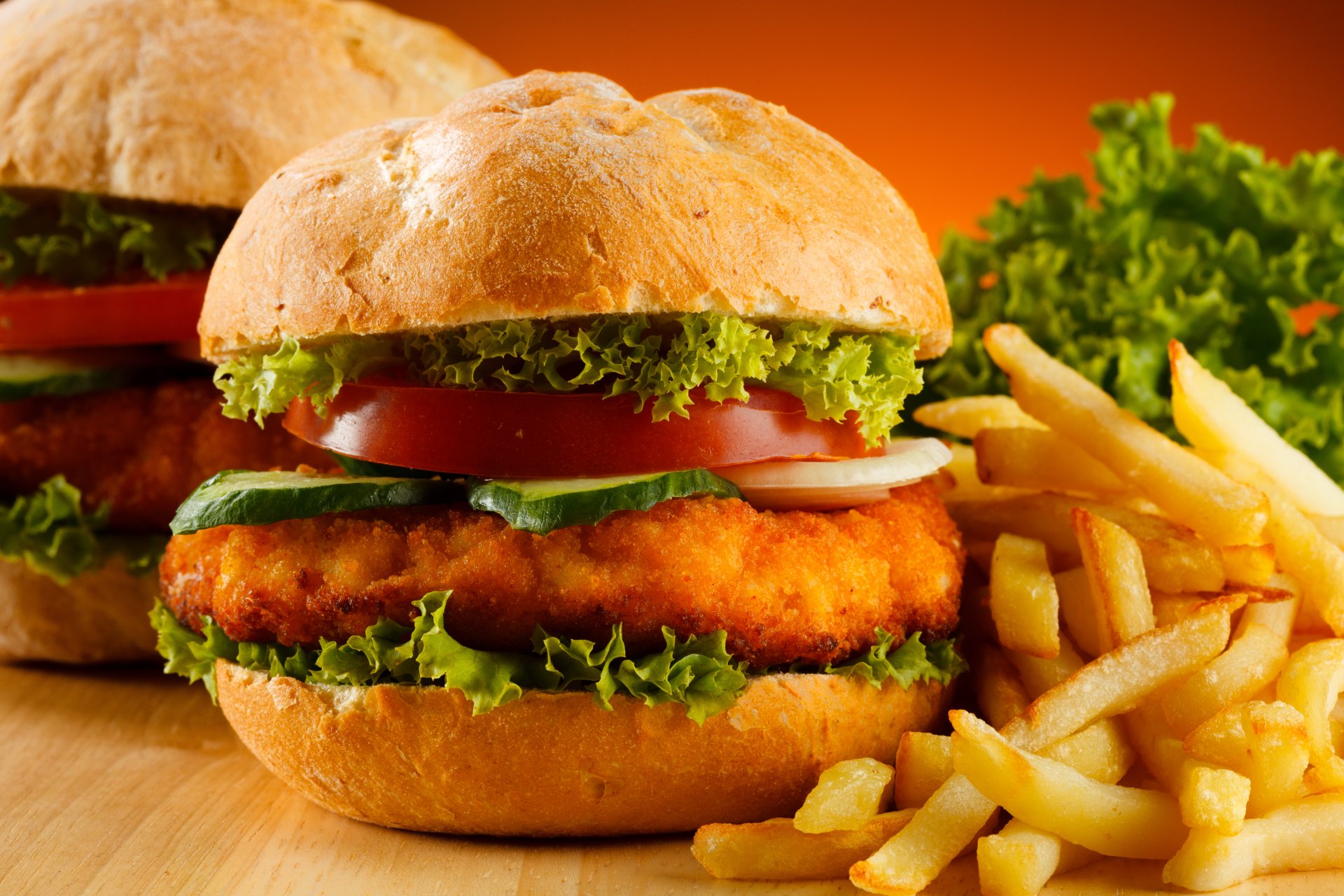 burgers french fries tomatoes cucumber salad table background