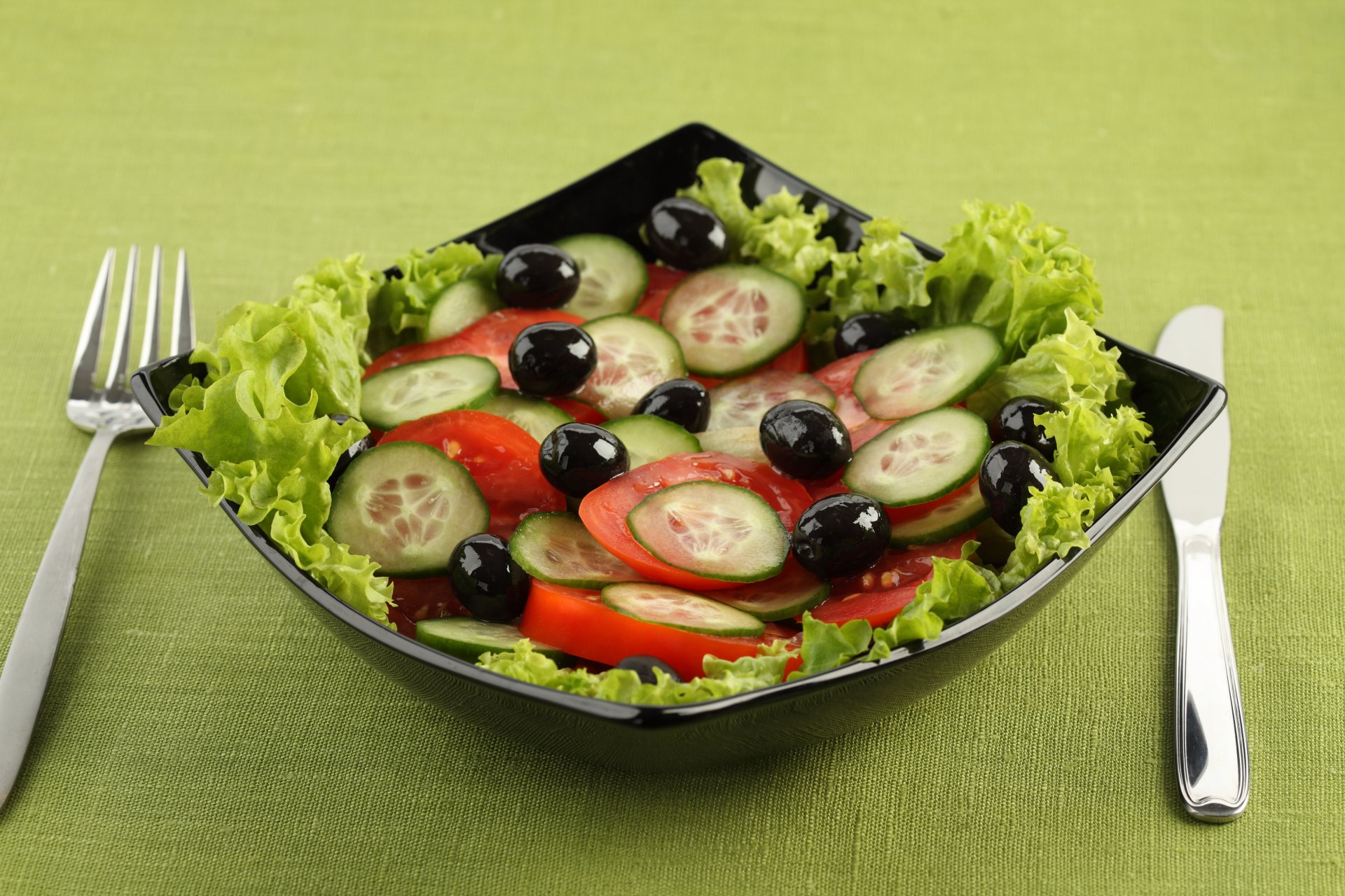 food salad knife fork dish tomatoes cucumber olive