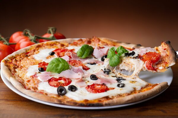 Fragrant pizza with olives, tomatoes and stretching cheese