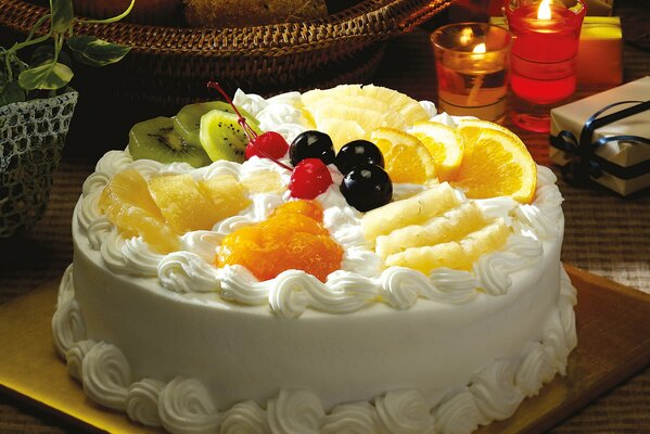 Белоснежный торт с фруктами на столе