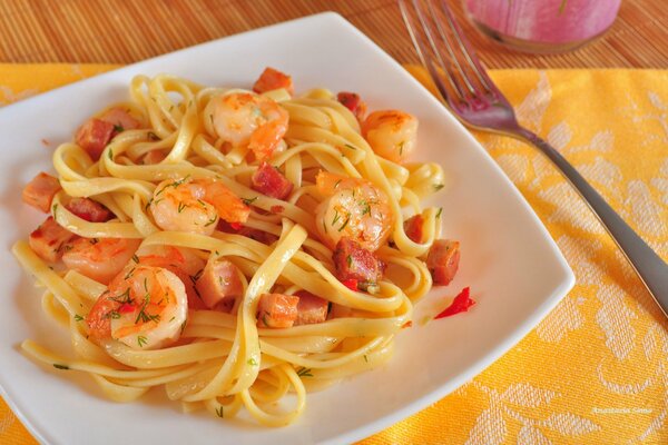 Delicious noodles with golden shrimp in a snow-white plate