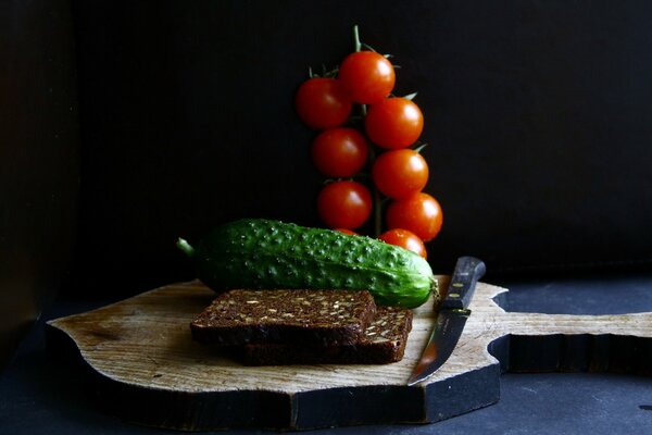 Black bread with cucumber and tomatoes on a board