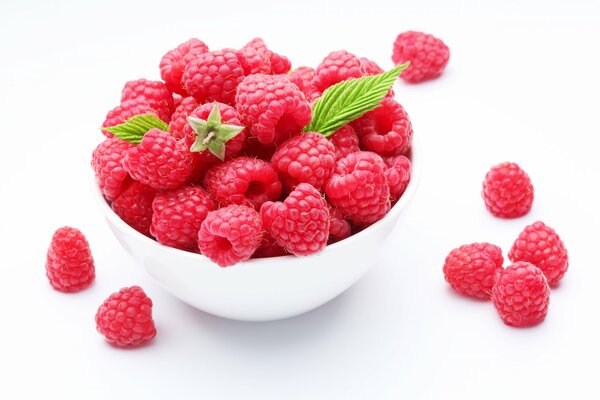 Raspberries crumbled slightly from a white bowl