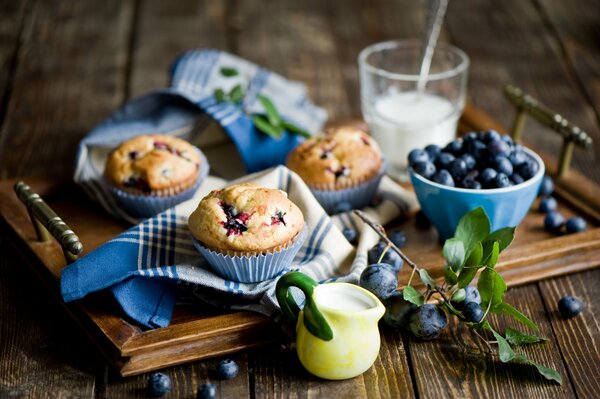 Nature morte avec l image de muffins, bleuets, lait situé sur un plateau