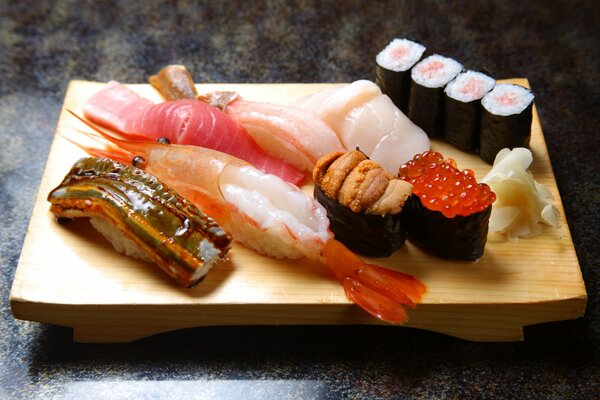 Rouleaux et sushis aux fruits de mer sur le tableau noir