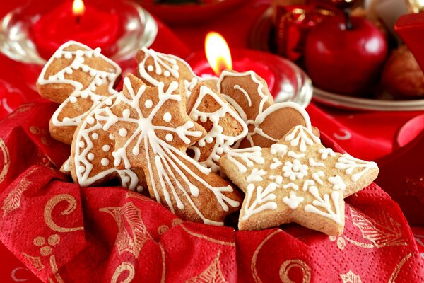 Galletas de Navidad, velas y manzanas en una servilleta roja