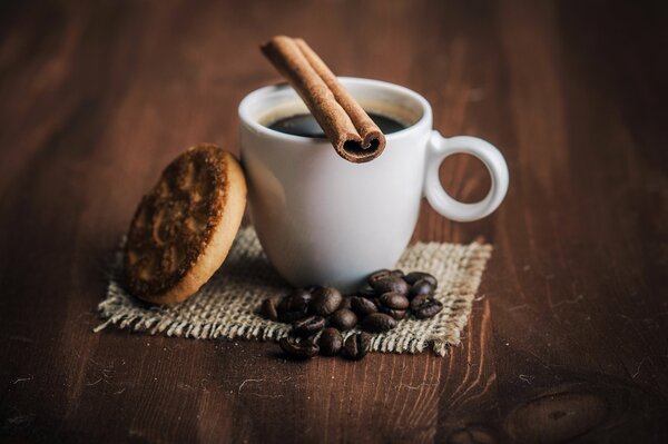 Tasse Kaffee mit Zimt und Keksen