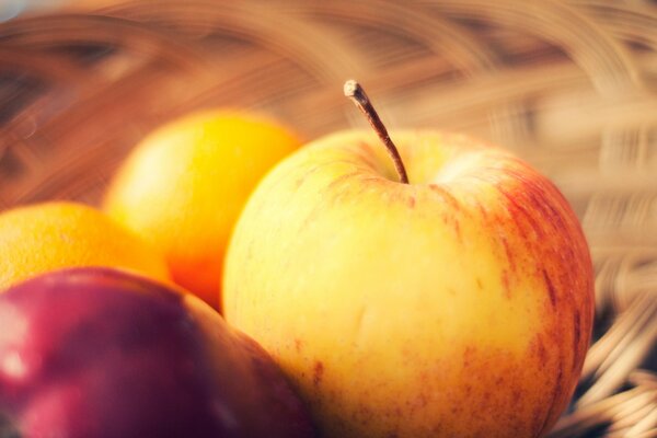 An apple in a fruit basket on a blurry background