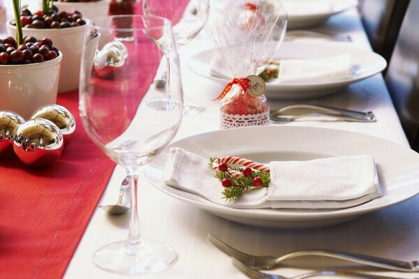 Table de service de Noël avec des boules d or, des baies et des baguettes sucrées