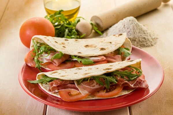 A plate with pita bread in which meat tomatoes and herbs