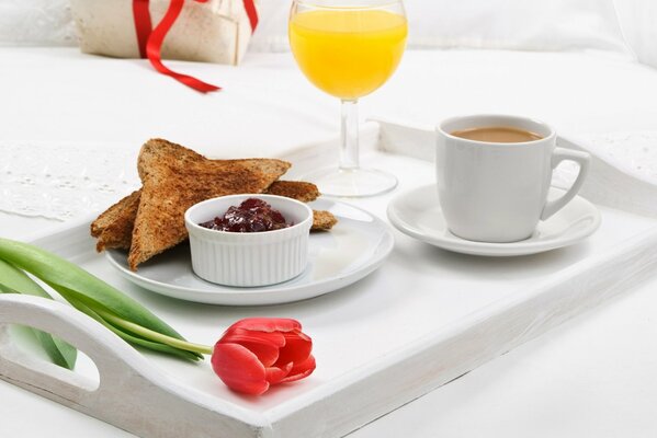 Morning breakfast with toast and jam, juice and coffee on a tray