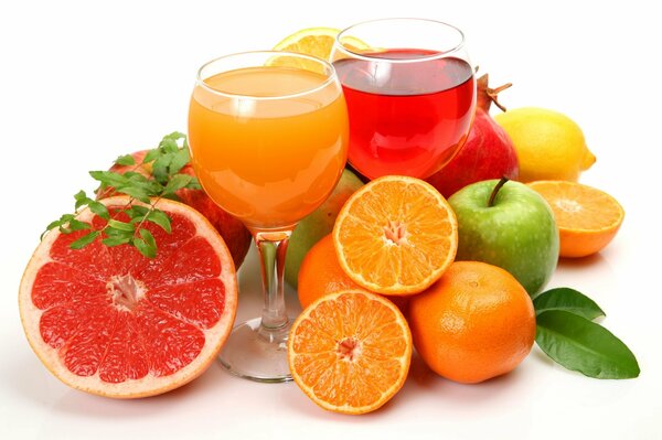 Verres avec du jus parmi les différents fruits