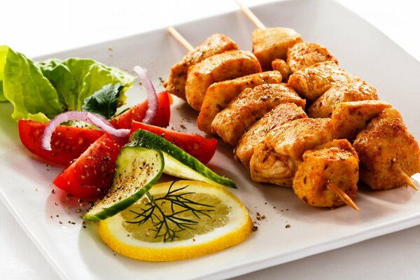 Barbecue with vegetables, herbs and lemon on a white tray