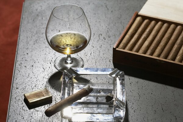 Embalaje de cigarros y alcohol en una Copa de vino