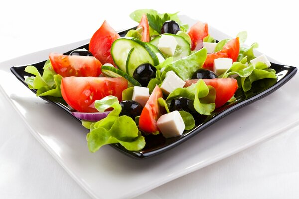 Greek salad on a black platter