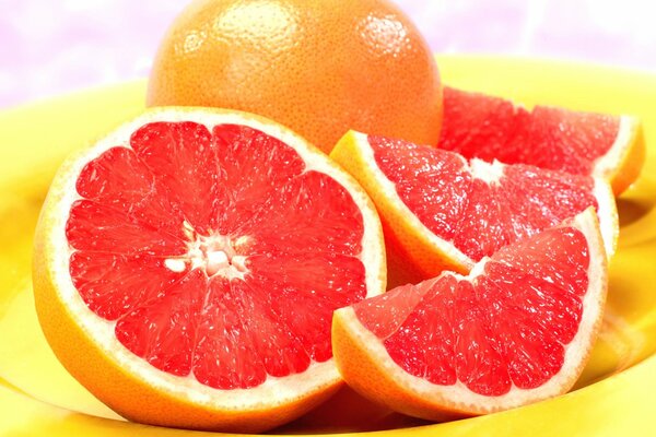 Juicy ripe grapefruit on a yellow plate