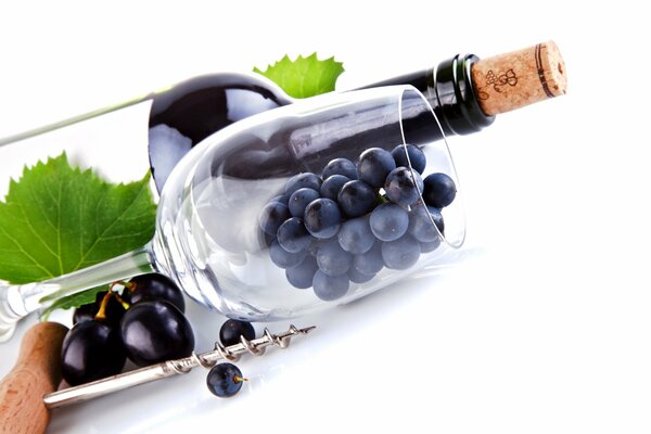 A beautiful glass with grapes and a bottle