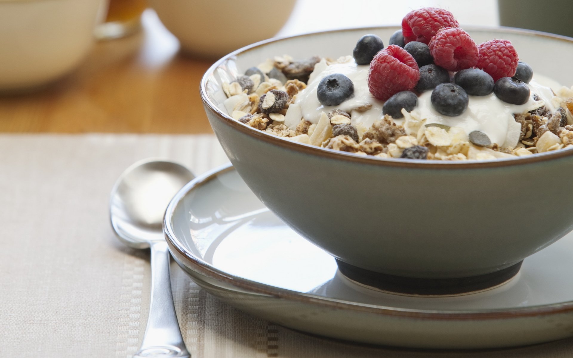essen süß frühstück müsli himbeeren blaubeeren rosinen teller löffel