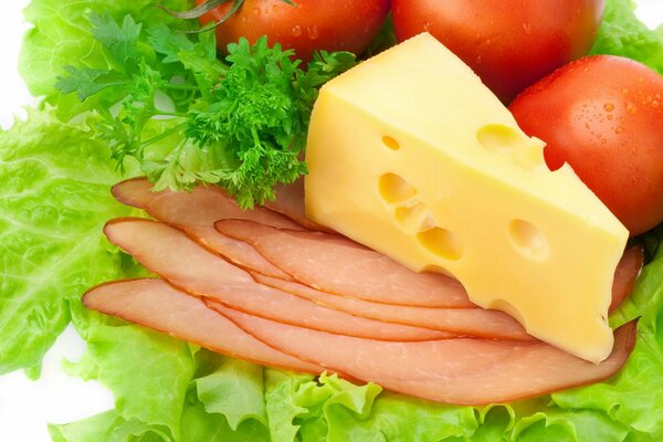 Ein Stück Käse und Deli auf Grüns