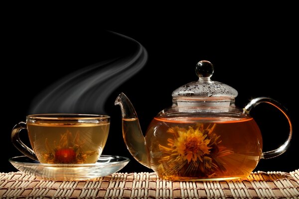 A teapot of tea with a blooming flower