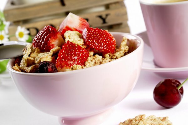 Dessert dolce con fragole e ciliegie in un piatto rosa