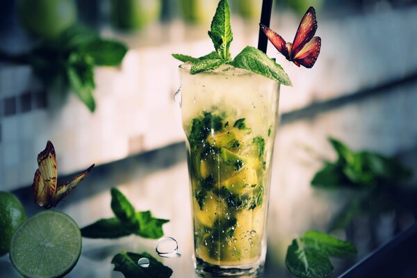 Cocktail Mojito su uno sfondo di verdure, lime e farfalle