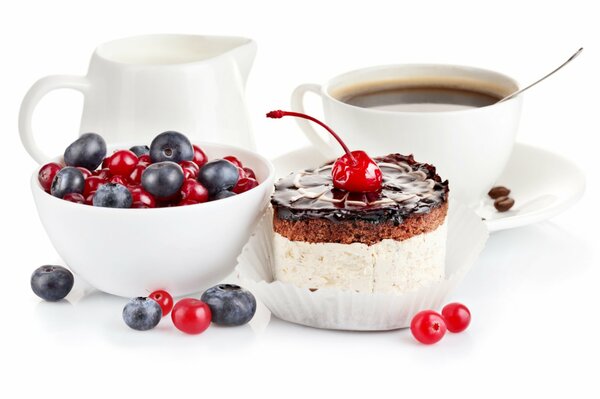 Kaffee mit Sahne und ein Teller mit Beeren