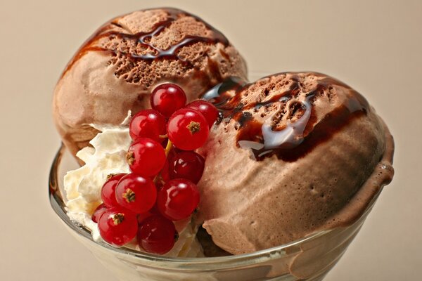 Crème glacée au chocolat avec des groseilles rouges dans un verre