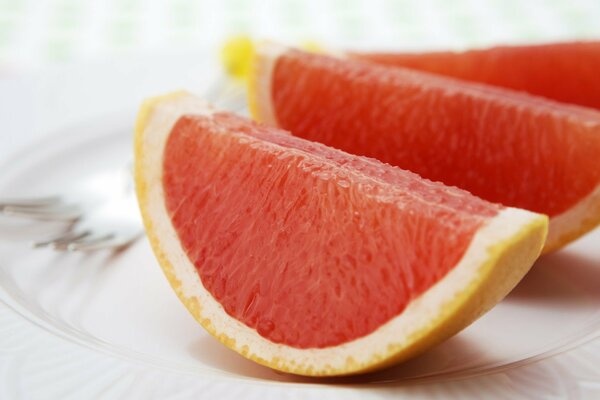 Gajos de pomelo en un plato blanco