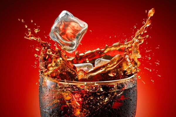 Coca-Cola splashes from a glass with ice