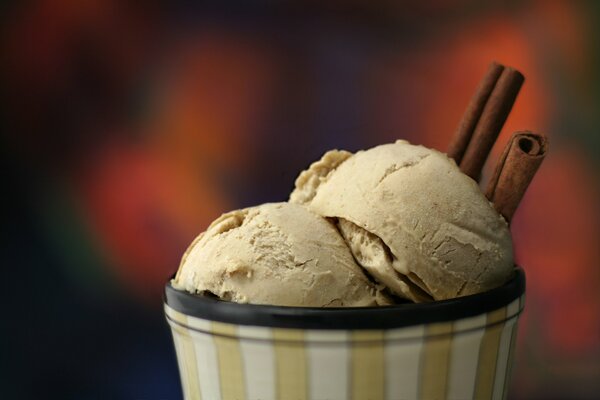 Cinnamon ice cream in a striped cream bowl on a blurry background