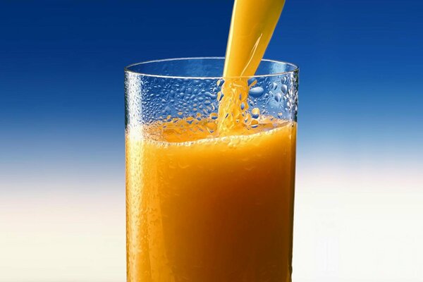 Un soplo de frescura y vitaminas. Jugo de naranja en un vaso empañado