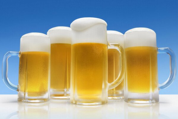 Foamy beer in mugs on the table