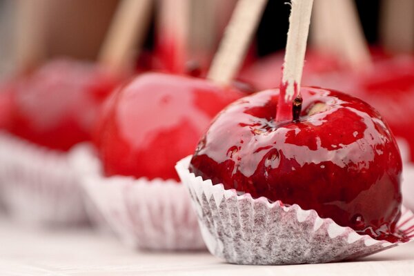 Mele rosse in caramello su un bastone