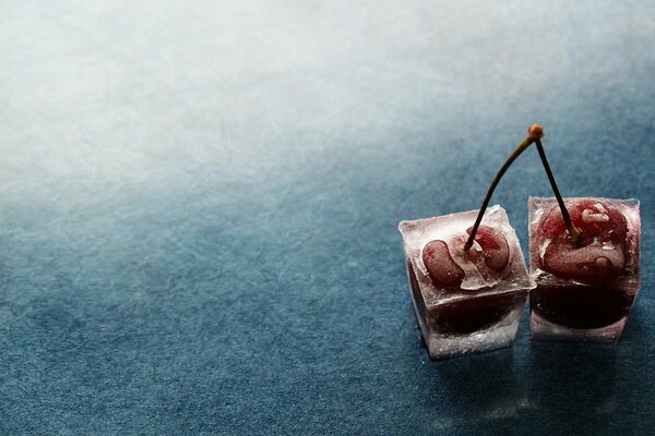 Two cherry berries in pieces of ice