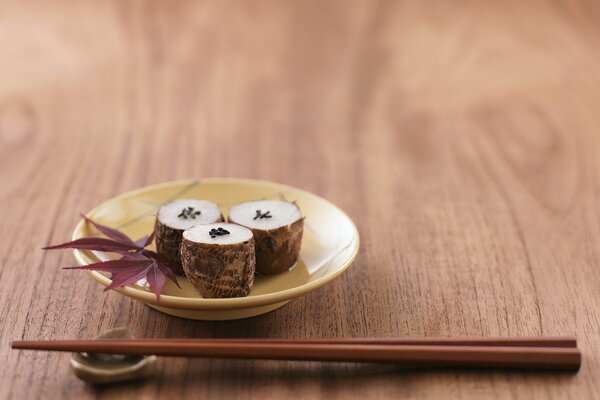 Sushi sur une assiette et avec des baguettes sur la table