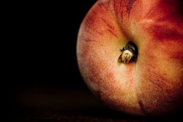 Laconic image of a peach on a black background