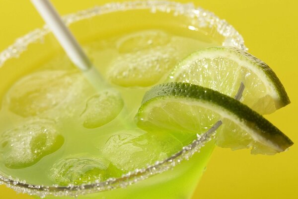 Boire dans un verre avec de la glace et des tranches de citron vert