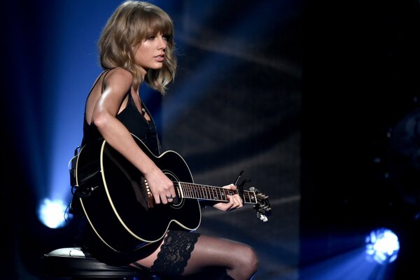 Taylor Swift with guitar at a concert