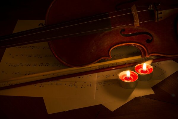 Violin and candles on musical notes