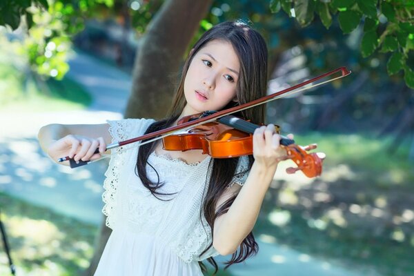 Jouer du violon fille dans le jardin