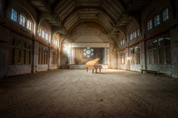 Pianoforte a coda solitario in una sala vuota