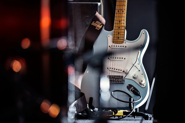 Chitarra blu su uno sfondo di luci sfocate