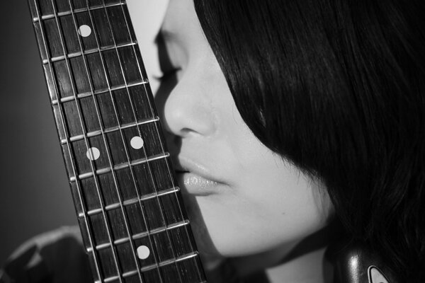 Black and white photo with a girl and a guitar