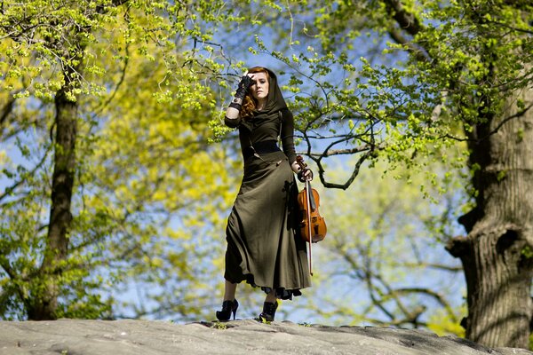 In the musical forest, violinist Hannah thiem poses in a beautiful dress