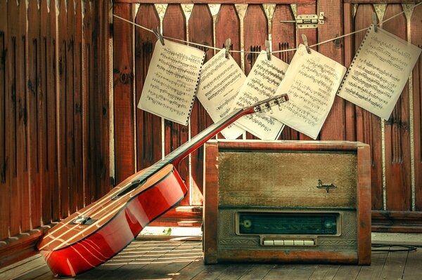 Guitarra y Radio vieja en el fondo de las notas colgadas