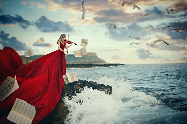 A girl playing the violin on the seashore