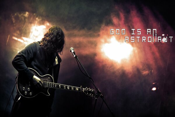 A rock artist with a guitar at the microphone under bright shields