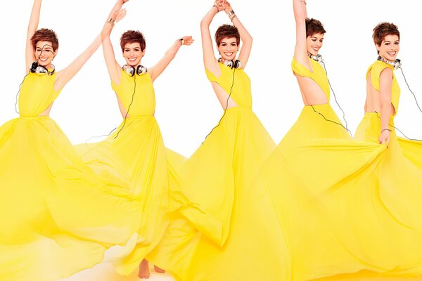 Anne Hathaway dances with headphones and a yellow dress